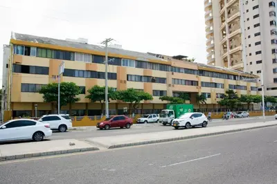 a parking lot with cars parked in front of a building at Apartamento Marbella - En Edificio Frente a la Playa cerca al centro Histórico in Cartagena de Indias