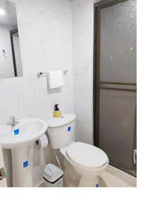 a white bathroom with a toilet and a sink at Apartamento Marbella - En Edificio Frente a la Playa cerca al centro Histórico in Cartagena de Indias