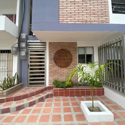 a building with a sign on the side of it at Aparta Suites Balcones de la Sierra in Fundación