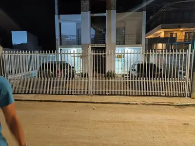 a white fence in front of a building with cars at Don Mathias # 1, Coveñas - Apartamento in Coveñas