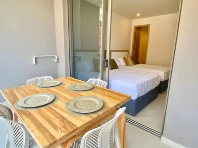 a room with a wooden table with chairs and a bed at Morros Zoe - Beautiful Apartment on Manzanillo Beach in Cartagena de Indias