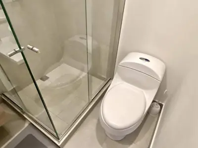 a bathroom with a toilet and a glass shower at Morros Zoe - Beautiful Apartment on Manzanillo Beach in Cartagena de Indias