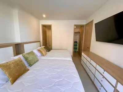 a bedroom with two beds and a flat screen tv at Morros Zoe - Beautiful Apartment on Manzanillo Beach in Cartagena de Indias
