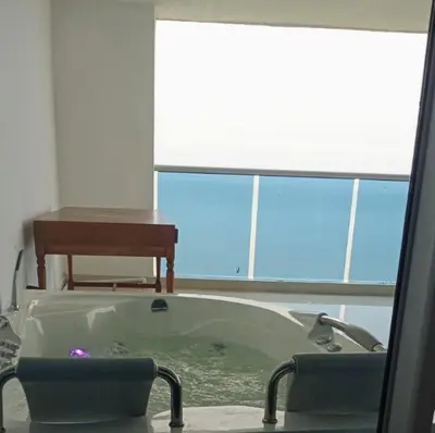 a bath tub in a room with a table and a chair at Penthouse vista panoramica frontal al mar 450 mts2 in Cartagena de Indias