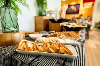 a table topped with plates of bread and pastries at Hilton Garden Inn Barranquilla in Barranquilla