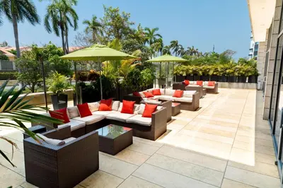 a patio with couches and umbrellas on a building at Hilton Garden Inn Barranquilla in Barranquilla