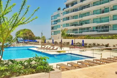 a swimming pool in front of a large building at Moderno 3 hab con la mejor Vista en playa dormida Santa Marta in Santa Marta
