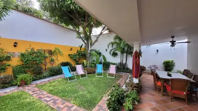 a patio with chairs and a table in a yard at Casa Blanca María Barranquilla - Authentic republican house in Barranquilla