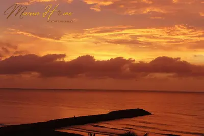 a sunset on the beach with the ocean at 2BR Oceanfront Apartment - Direct Beach Access - Modern and Spacious - 6th Floor in Cartagena de Indias