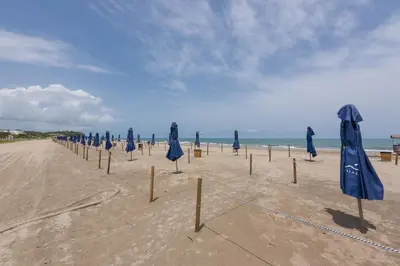 a row of blue umbrellas on the beach at Lujoso Apartamento Con Salida Directa A La Playa Edificio Morros Eco in Cartagena de Indias