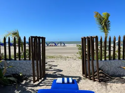 two blue chairs and a fence on the beach at Casa El Faro, Hermosa casa de playa in Cartagena de Indias