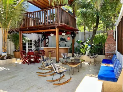 a patio with a deck with chairs and a table at Casa El Faro, Hermosa casa de playa in Cartagena de Indias