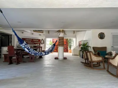 a living room with a hammock in the middle of the room at Casa El Faro, Hermosa casa de playa in Cartagena de Indias