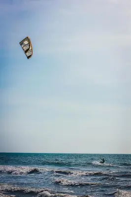 a person flying a kite over the ocean at Apartamento a unos pasos de la playa in Cartagena de Indias