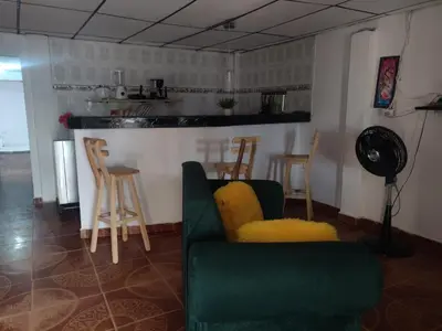 a living room with a green couch and chairs at Apartamento a unos pasos de la playa in Cartagena de Indias
