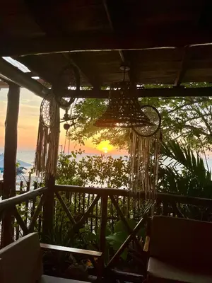 a view of the sunset from a porch with chandeliers at Thani Ecobeach Barú in Playa Blanca