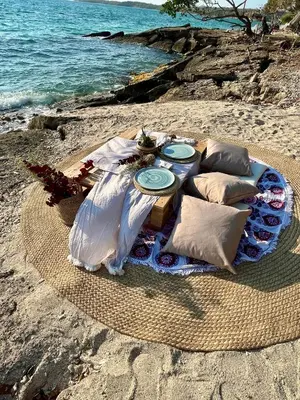a picnic table on the beach near the water at Thani Ecobeach Barú in Playa Blanca