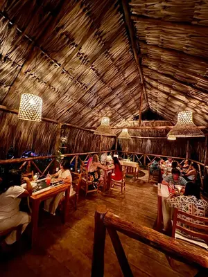 a group of people sitting at tables in a restaurant at Thani Ecobeach Barú in Playa Blanca