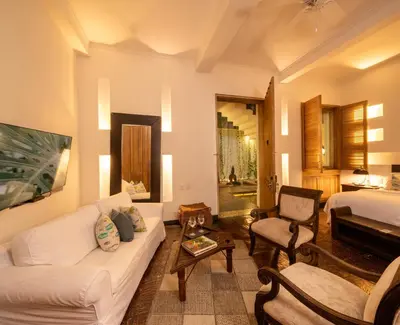 a living room with a white couch and a bed at Casa Belle Cartagena Hotel Boutique in Cartagena de Indias