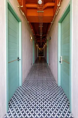 an empty hallway with blue doors and a tile floor at Bondo Estudio in Cartagena de Indias