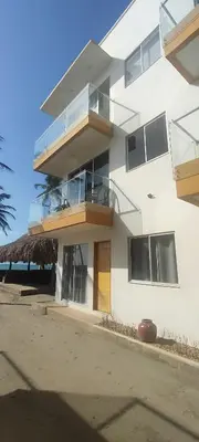 a white building with a balcony and the ocean at Apartamento 201 Palmar de los vientos in San Bernardo del Viento