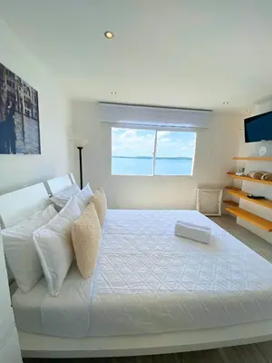a white bedroom with a large bed with a window at U-GO Playa Mar en El Laguito con Vista al Mar in Cartagena de Indias