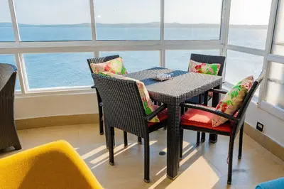 a table and chairs in a room with a large window at U-GO Playa Mar en El Laguito con Vista al Mar in Cartagena de Indias