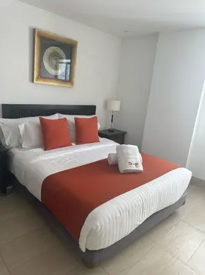a bedroom with a large bed with red and white pillows at U-GO Playa Mar en El Laguito con Vista al Mar in Cartagena de Indias