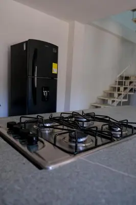 a stove top in a kitchen with a refrigerator at Cabañas en San Antero Bambumar3 in San Antero