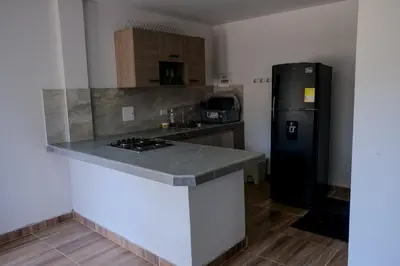a kitchen with a black refrigerator and a counter at Cabañas en San Antero Bambumar3 in San Antero