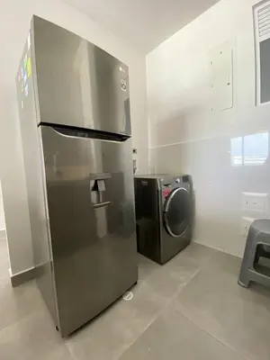 a stainless steel refrigerator and a washing machine in a kitchen at Morros Cartagena frente a playa Hotel las Américas Edificio Spiaggia Apto Duplex in Cartagena de Indias