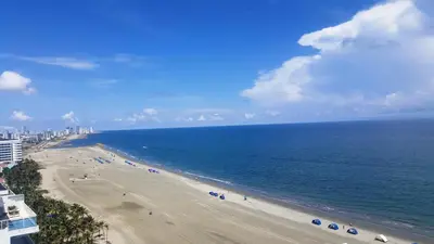 a view of a beach with umbrellas and the ocean at Morros Cartagena frente a playa Hotel las Américas Edificio Spiaggia Apto Duplex in Cartagena de Indias
