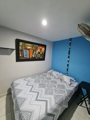 a bedroom with a bed and a tv on the wall at Apartamentos La Marina in Cartagena de Indias