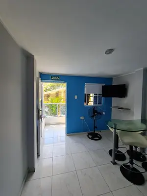 a room with a table and a blue wall at Apartamentos La Marina in Cartagena de Indias