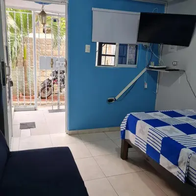 a bedroom with a bed and a blue wall at Apartamentos La Marina in Cartagena de Indias