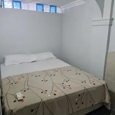 a bedroom with a bed with a bedspread with a tree pattern at Apartamentos La Marina in Cartagena de Indias