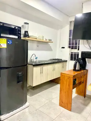 a kitchen with a black refrigerator and a wooden table at Apto Boho in Cartagena de Indias