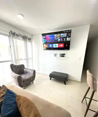 a living room with a couch and a chair and a flat screen tv at Apartamento vacacional cerca del mar in Cartagena de Indias