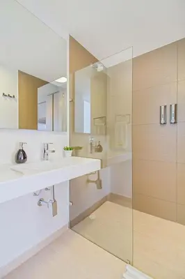 a bathroom with two sinks and a glass shower at U-GO Edificio Faro en El Laguito, Cartagena in Cartagena de Indias