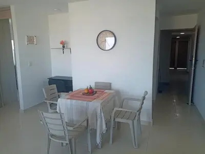 a dining room table with chairs and a clock on the wall at apartamento1108 in Cartagena de Indias