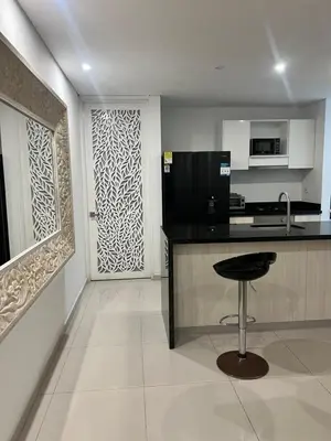 a kitchen with a black counter and a stool at Cartagena Seaview Elegance in Cartagena de Indias