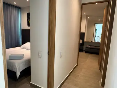 a door to a bedroom with a bed and a mirror at Tres habitaciones - Vista al Mar in Cartagena de Indias