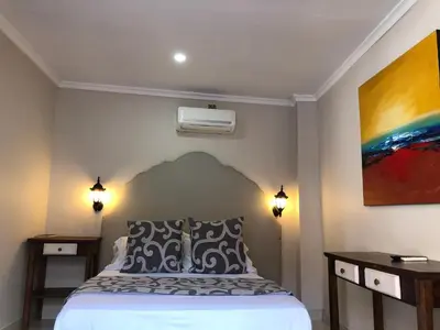a bedroom with a bed and a painting on the wall at Hotel Galeria la Trinidad in Cartagena de Indias