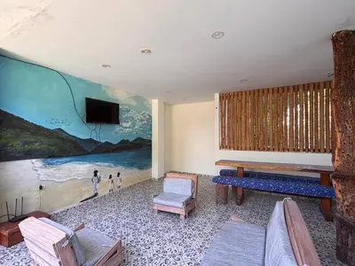 a living room with a large painting on the wall at Hostal Los Arhuacos in Santa Marta
