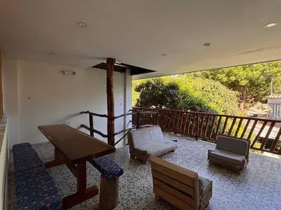 a porch with a bench and a table and chairs at Hostal Los Arhuacos in Santa Marta