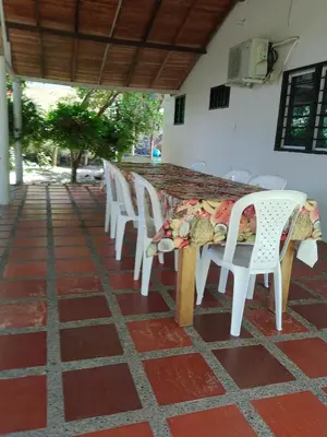 a row of white chairs and a table on a patio at Mágica Cabaña familiar cerca al mar in Coveñas