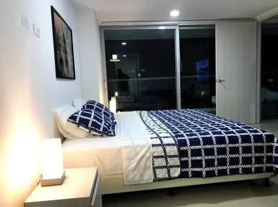 a bedroom with a bed with a blue and white blanket at Sensacional Apartamento nuevo frente al mar in Cartagena de Indias