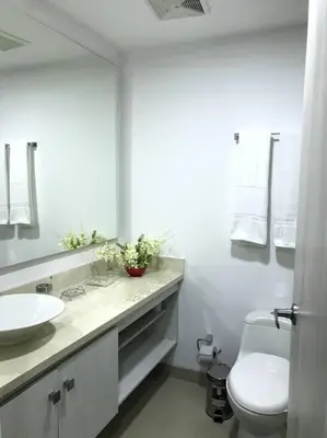 a bathroom with a sink and a toilet and a mirror at Sensacional Apartamento nuevo frente al mar in Cartagena de Indias
