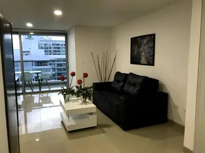 a living room with a black couch and a table at Sensacional Apartamento nuevo frente al mar in Cartagena de Indias