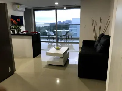 a living room with a black couch and a table at Sensacional Apartamento nuevo frente al mar in Cartagena de Indias